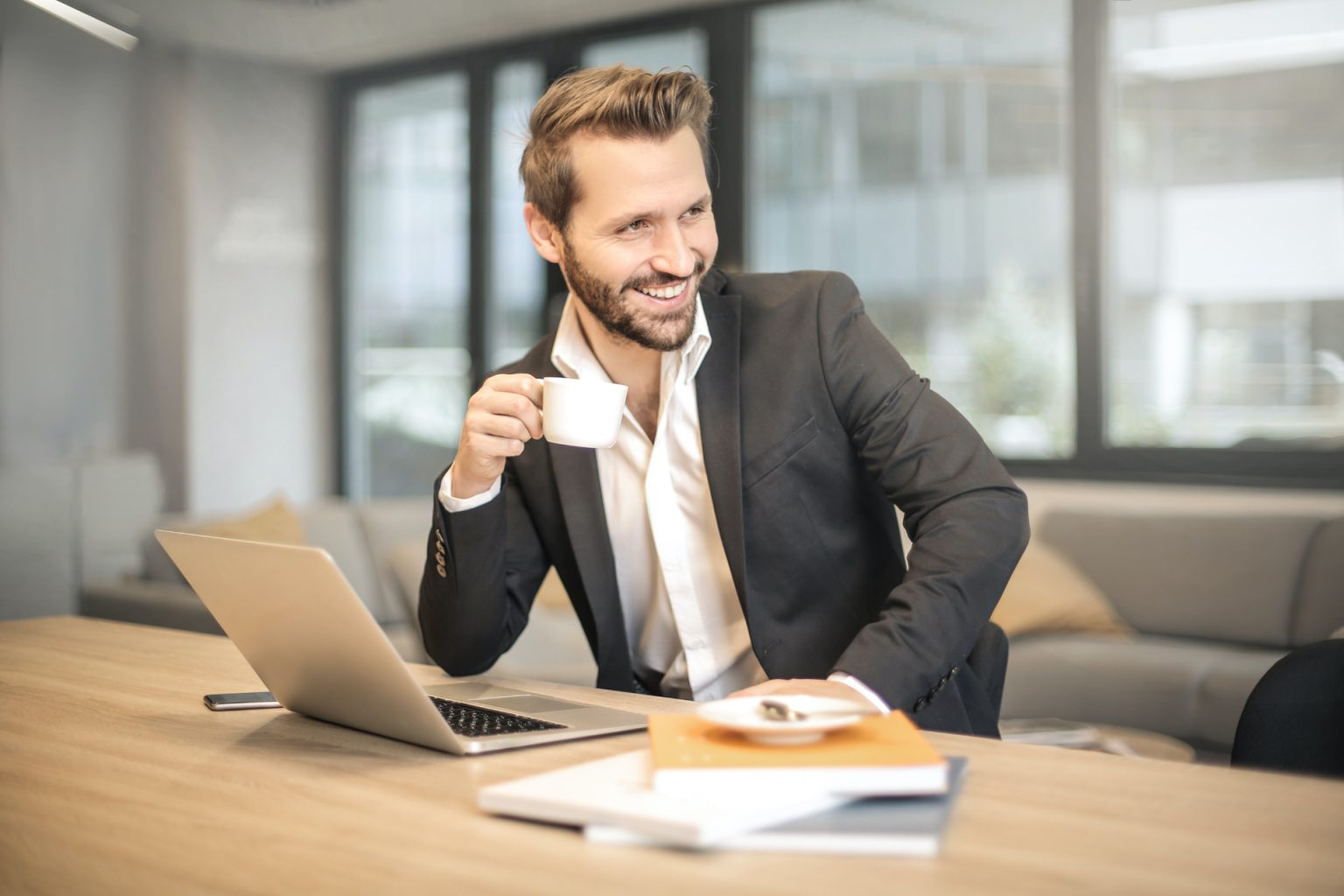 Investor smiling at his laptop in an office